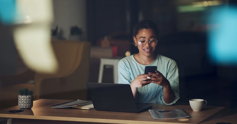 Woman viewing her ETF dividends on phone and laptop